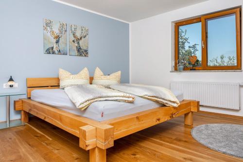 a bedroom with a wooden bed in a room at Ferienwohnung Auf Dem Haldershof in Wangen im Allgäu