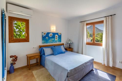 ein Schlafzimmer mit einem blauen Bett und einem Fenster in der Unterkunft S Estanyol in Colònia de Sant Pere