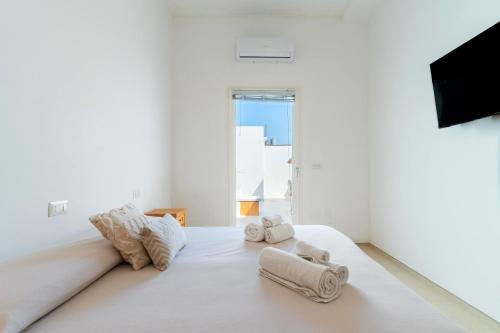 - une chambre blanche avec des serviettes sur un lit dans l'établissement Dimora delle Riserve Naturali, à Torre Colimena