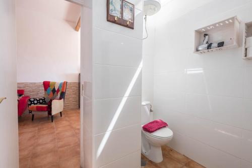 ein weißes Bad mit einem WC und einem Stuhl in der Unterkunft Casa Cardón - Villa Perenquén in Guía de Isora
