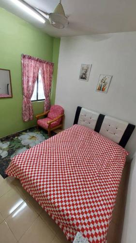 a bedroom with a bed with a red and white blanket at Idah Homestay Bandar Tasik Puteri in Rawang