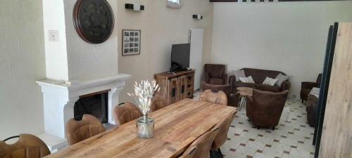 a living room with a table and a fireplace at L'Oustau de Maître Potager in Valréas