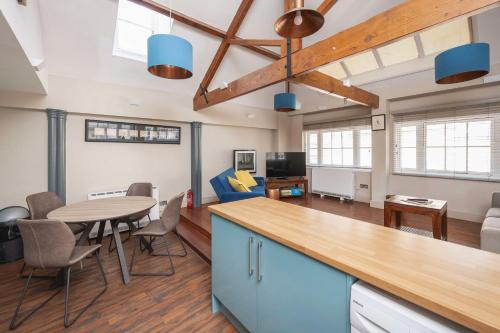 a kitchen and living room with a table and chairs at Dream Stays Bath - Queen Street Loft Apartment in Bath