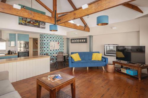 a living room with a blue couch and a tv at Dream Stays Bath - Queen Street Loft Apartment in Bath