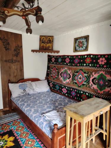 a bedroom with a bed and a table in it at Căsuța de chirpici in Dunavăţu de Sus
