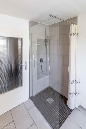 a bathroom with a shower with a glass door at Ferienhaus S`bunde Heisle in Blaufelden