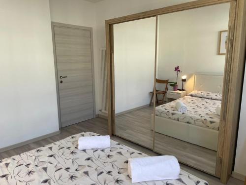 a mirror in a room with a bed and a bedroom at Appartamento Iris in Mori