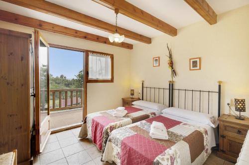 SagásにあるLes Casesのバルコニー付きの客室内のベッド2台