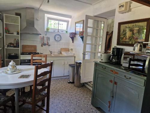 une cuisine avec une table et un comptoir dans l'établissement Chez Poton, à Le Grand-Bourg