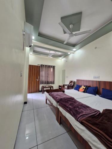 a bedroom with two beds and a ceiling at TARA Guest House in Ujjain