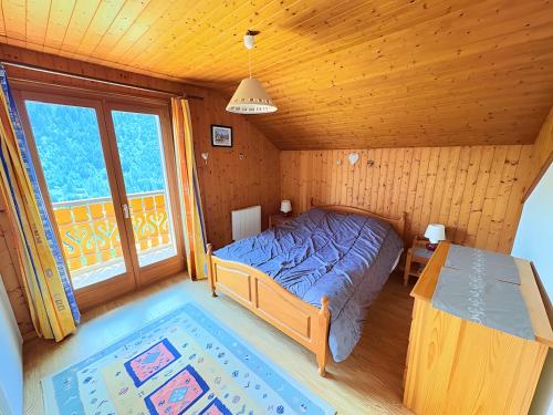 a bedroom with a bed in a wooden room at Chalet Loupnots 3P avec vue in Châtel