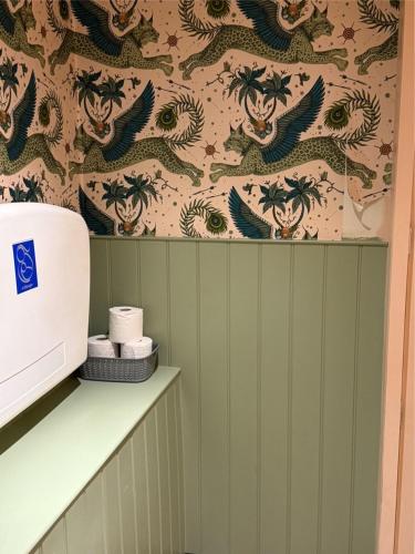 シャーボーンにあるBritannia innの壁に龍の壁紙が貼られたバスルーム