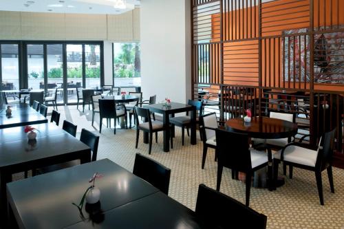 a dining room with tables and chairs and windows at Staybridge Suites Yas Island Abu Dhabi by IHG in Abu Dhabi
