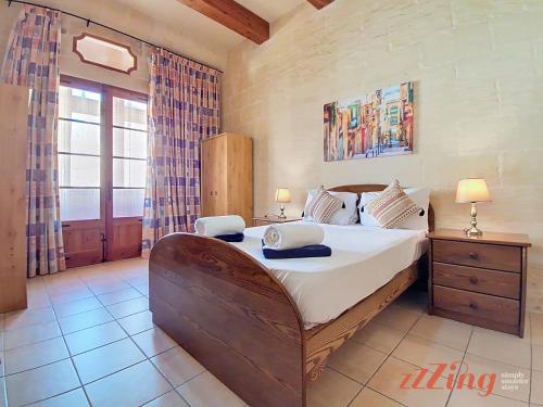 a bedroom with a large bed in a room at Gozo Farmhouse Escape with Rustic Charm & Pool in Sannat
