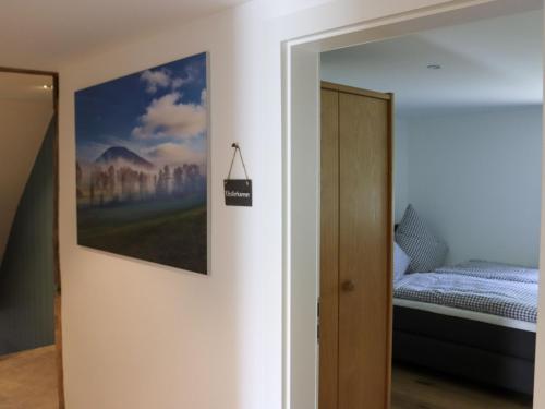 Un dormitorio con una cama y un cuadro en la pared. en Rübenkämpers Ferienwohnungen, en Schmallenberg