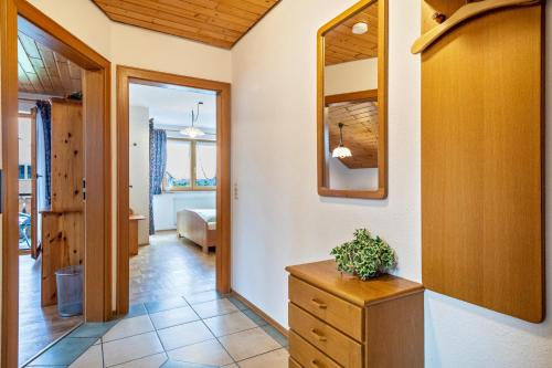 un couloir avec une commode et un miroir dans l'établissement Drei-Mädelhaus Ambs Wohnung 1, à Ravensbourg
