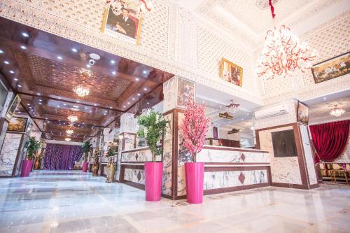 a lobby with pink vases on the floor of a building at Appart Hotel Les Ambassadeurs in Marrakech