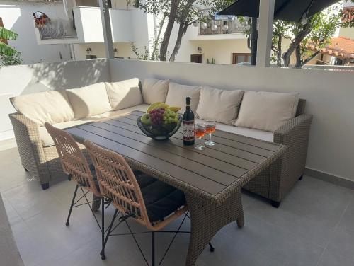 a table with a bottle of wine and a bowl of fruit at Avres Apartments in Skiathos Town