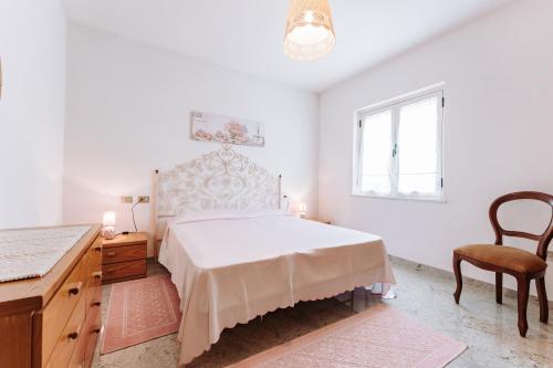 a bedroom with a bed and a desk and a chair at Casa Antonietta in SantʼAnna Arresi