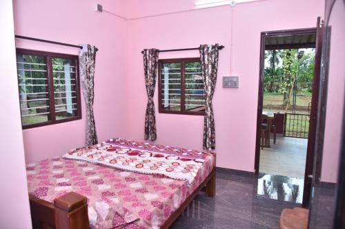 a bedroom with pink walls and a bed and windows at Lewis Paradise Homestay in Kalyānpur
