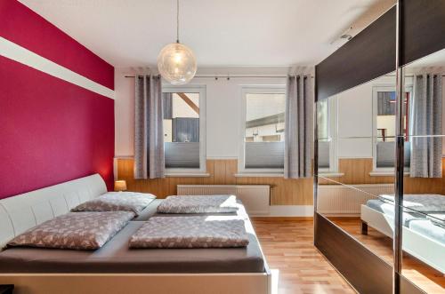 ein Schlafzimmer mit zwei Betten und einer roten Wand in der Unterkunft Ferienwohnung Gräfe in Herzberg am Harz