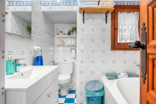 a bathroom with a toilet and a sink and a tub at Casa Trinidad in Denia
