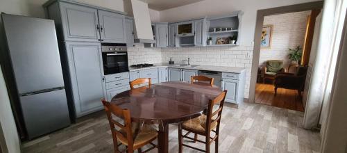 eine Küche mit Tisch und Stühlen und einem Kühlschrank in der Unterkunft Ô Loue Rétro - 6 personne - 1er étage in Quingey