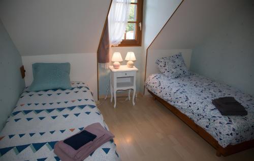 a small bedroom with two beds and a table at Maison - Le Clos Des Pommiers in La Vicomté-sur-Rance