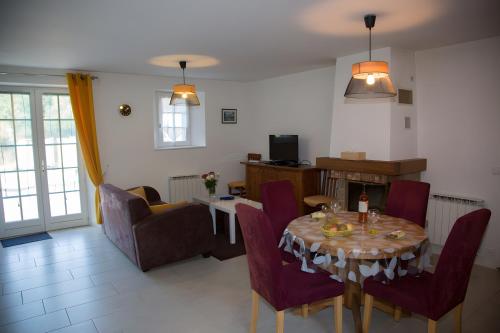 a living room with a table and chairs and a living room at Maison - Le Clos Des Pommiers in La Vicomté-sur-Rance