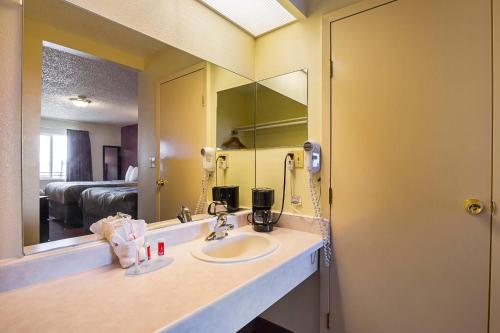 a bathroom with a sink and a large mirror at Econo Lodge Hurricane Zion Park Area in Hurricane