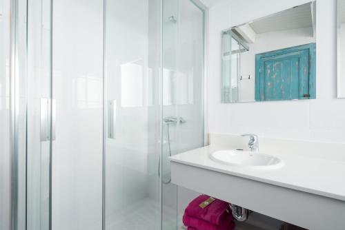 ein weißes Badezimmer mit Waschbecken und Dusche in der Unterkunft Blue Beach House ATICO CON TERRAZA in Málaga