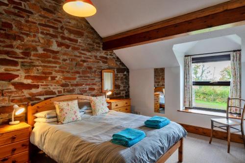 ein Schlafzimmer mit einem Bett mit blauen Handtüchern darauf in der Unterkunft Finest Retreats - Old Nog Cottage, Stowford in Little Torrington