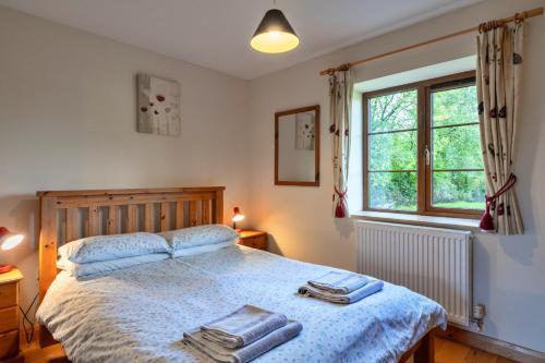 a bedroom with a bed with towels on it at Finest Retreats - Tarkas Holt Log Cabin, Stowford in Little Torrington