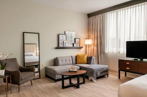 a living room with a couch and a tv at St Charles Coach House, an Ascend Collection Hotel in New Orleans