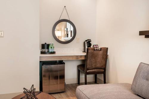 um quarto com uma secretária com um espelho e uma cadeira em St Charles Coach House, an Ascend Collection Hotel em Nova Orleães