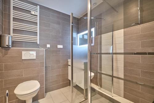 een badkamer met toilet en glazen douche bij Marmotte rdc in Les Deux Alpes