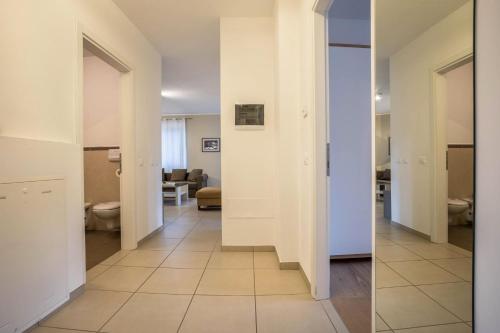 a hallway with white walls and a tile floor at Residence La Villa Tesoro in Tignale