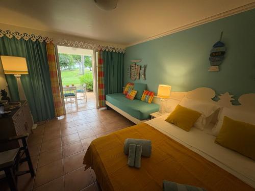 a bedroom with a bed and a living room at TI COCOTIER Studio PREMIUM Village Vacances in Sainte-Luce