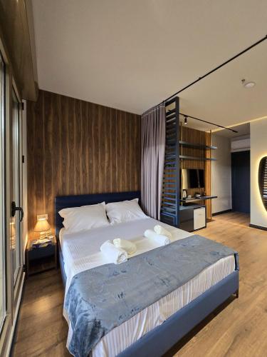 a bedroom with a large bed with towels on it at SOLs Center Rooms in Tirana