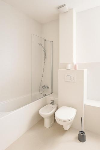 a white bathroom with a toilet and a shower at Hyper Centre DEAUVILLE 3 chambres in Deauville