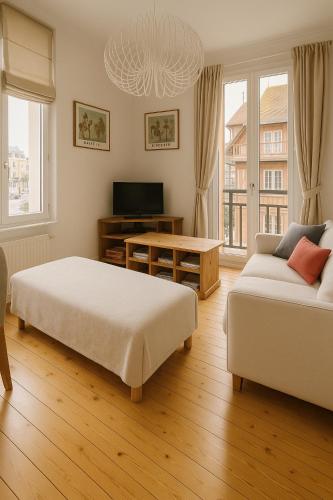 a bedroom with two beds and a couch and a tv at Hyper Centre DEAUVILLE 3 chambres in Deauville