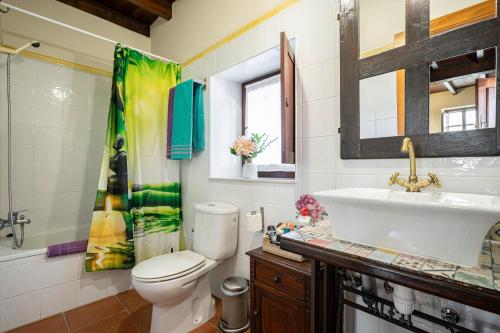 ein Badezimmer mit einer weißen Toilette und einem Waschbecken in der Unterkunft La Casina Del Fresnu in Onón