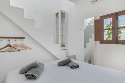 a white room with a bed with two towels on it at Casa Vejer con vistas y garaje in Vejer de la Frontera