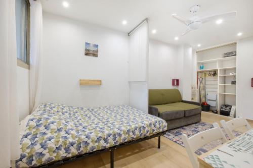 een kleine slaapkamer met een bed en een bank bij Studio - 2 couchages doubles in Villeneuve-Loubet