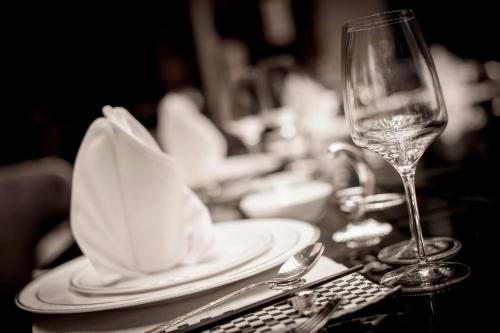 a table with plates and a wine glass on it at Sanding New Century Grand Hotel Yiwu in Yiwu