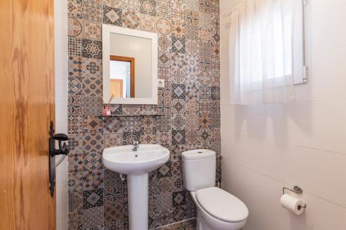 a bathroom with a toilet and a sink and a mirror at Hygee in San Javier