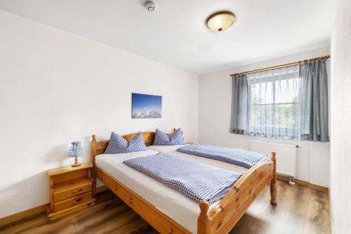 ein Schlafzimmer mit einem Holzbett mit blauen Kissen in der Unterkunft Fewo Brünnstein - Nr 44 Pool, Sauna in Oberaudorf