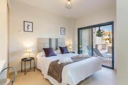 a bedroom with a large bed and a balcony at El Oasis Malta 2 Bajo A in Fuente Alamo