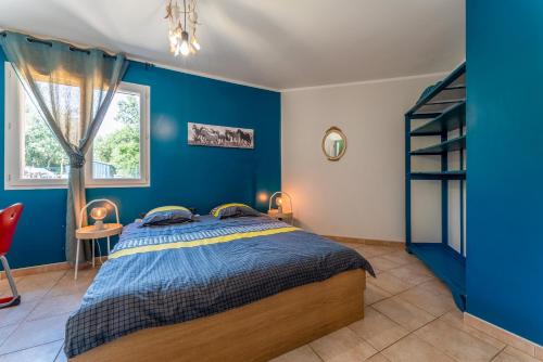 a blue bedroom with a bed and a window at Villa in Méjannes-le-Clap