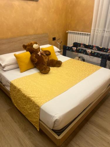 a teddy bear sitting on top of a bed at Appartamento feriolo Margherita in Baveno
